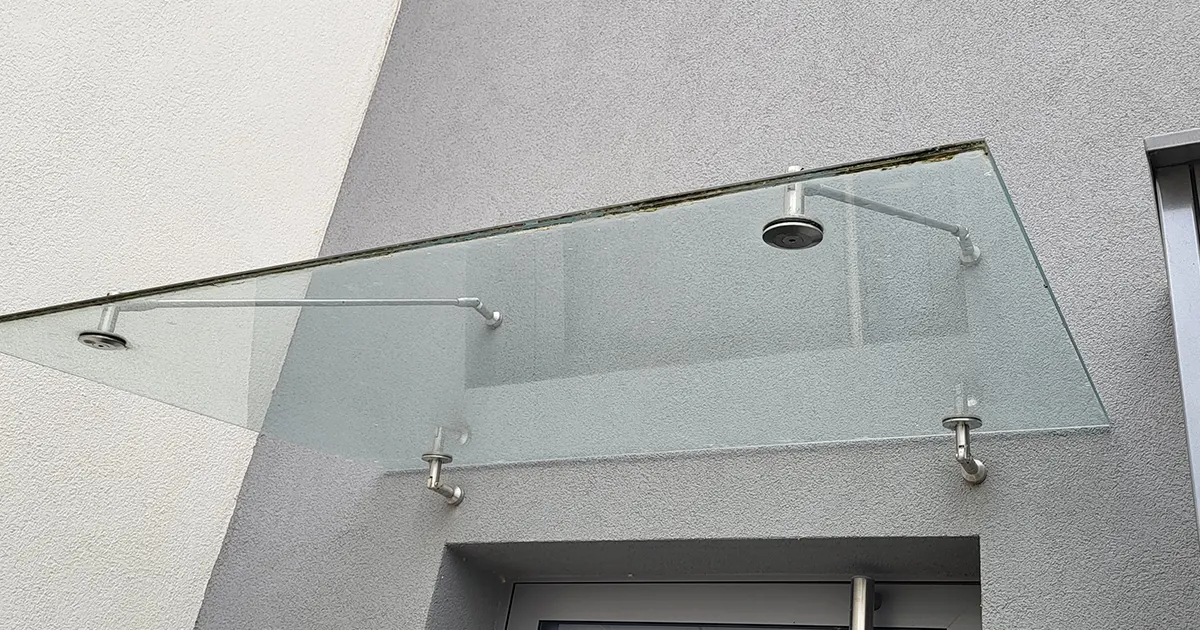 Détail du vitrage feuilleté et des fixations inox d'une avancée de toit posée par Mirco, miroiterie à Colmar